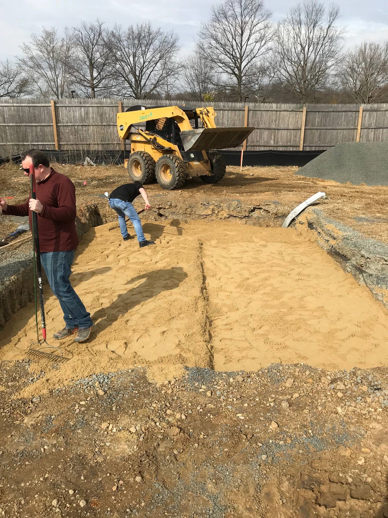 ANC horticulture staff installing a sand layer on an in-ground crypt