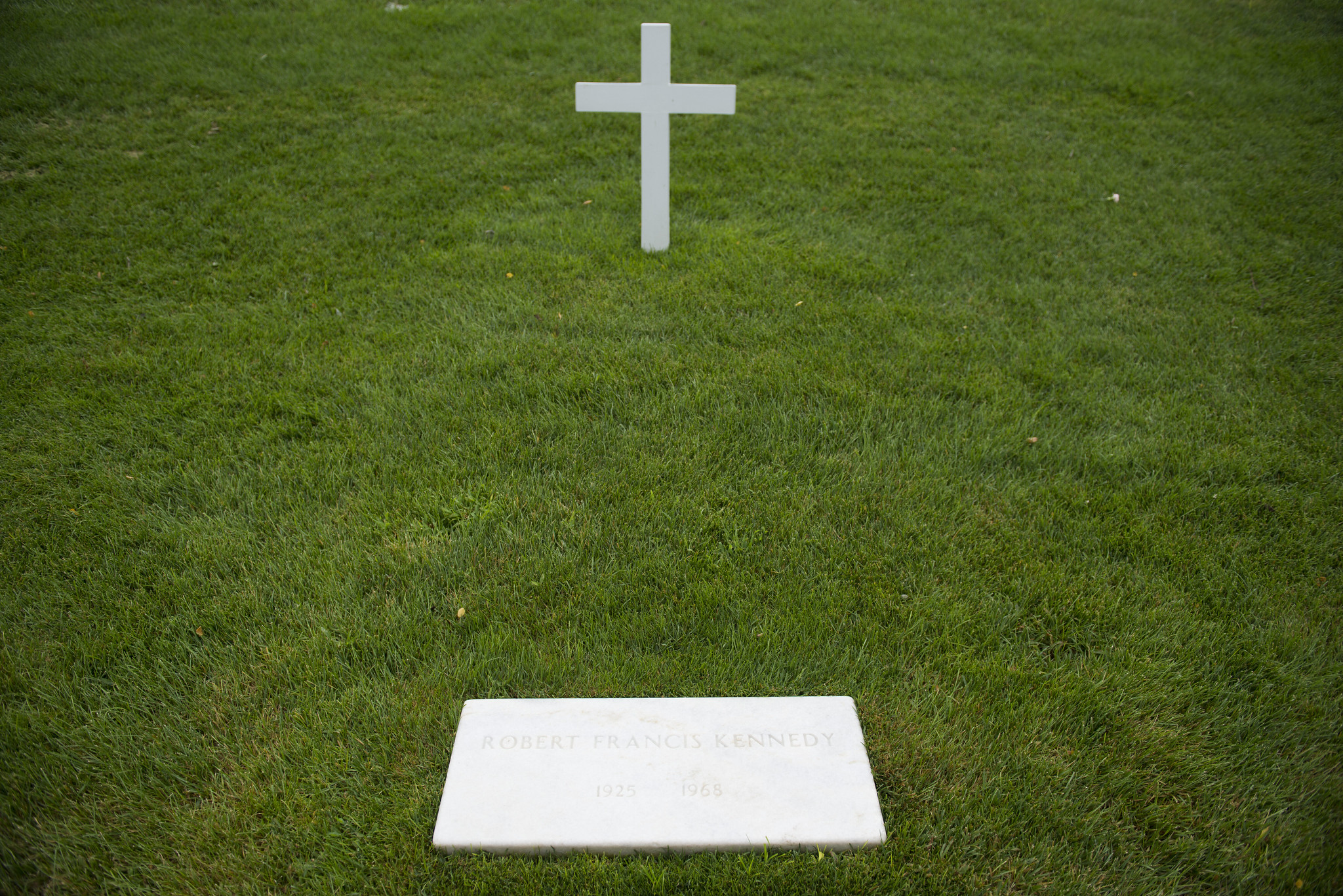 explore-monuments-rfk A simple white cross and flat marker at the gravesite of Robert F. Kennedy