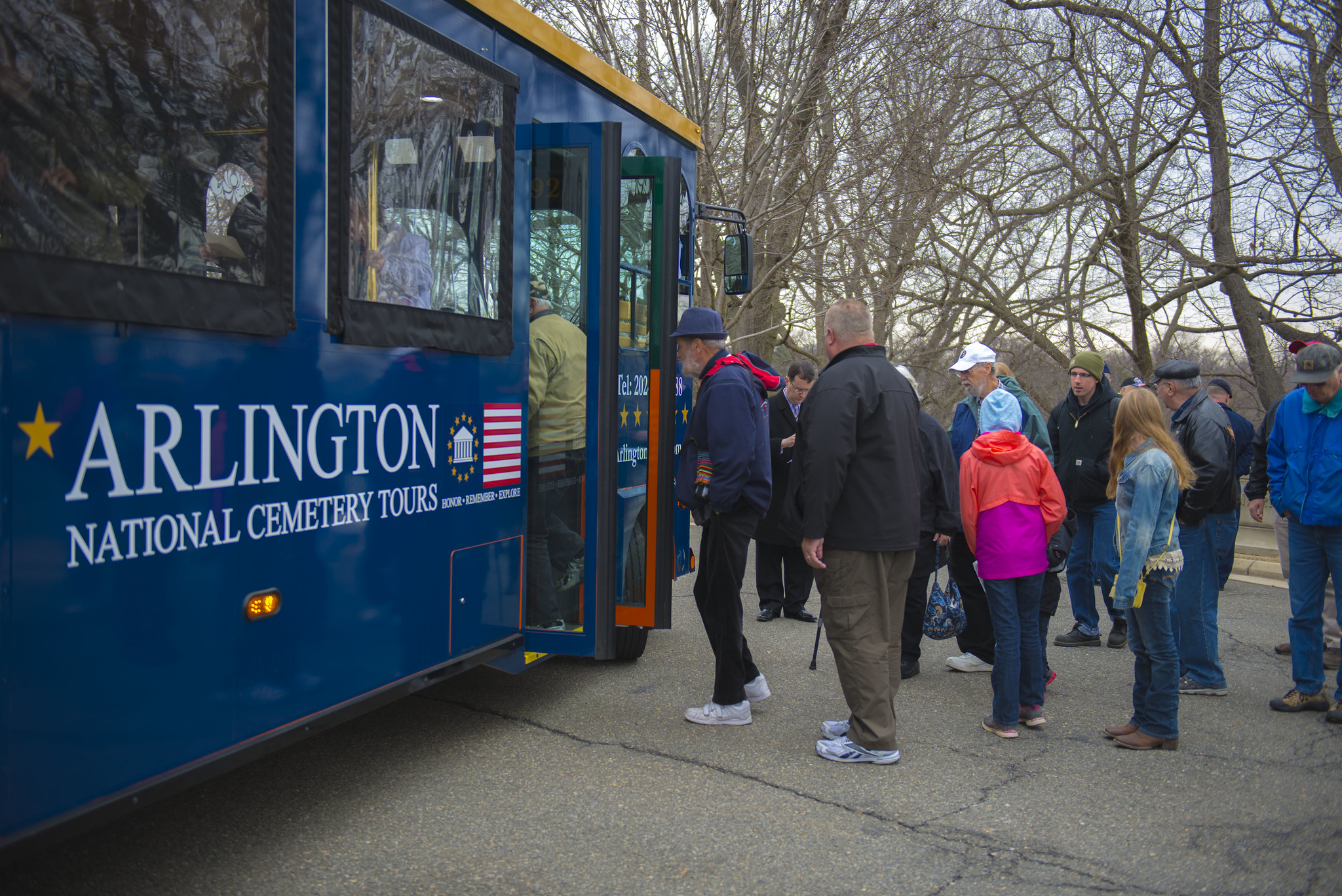 Visitors to Arlington National Cemetery board a tour bus