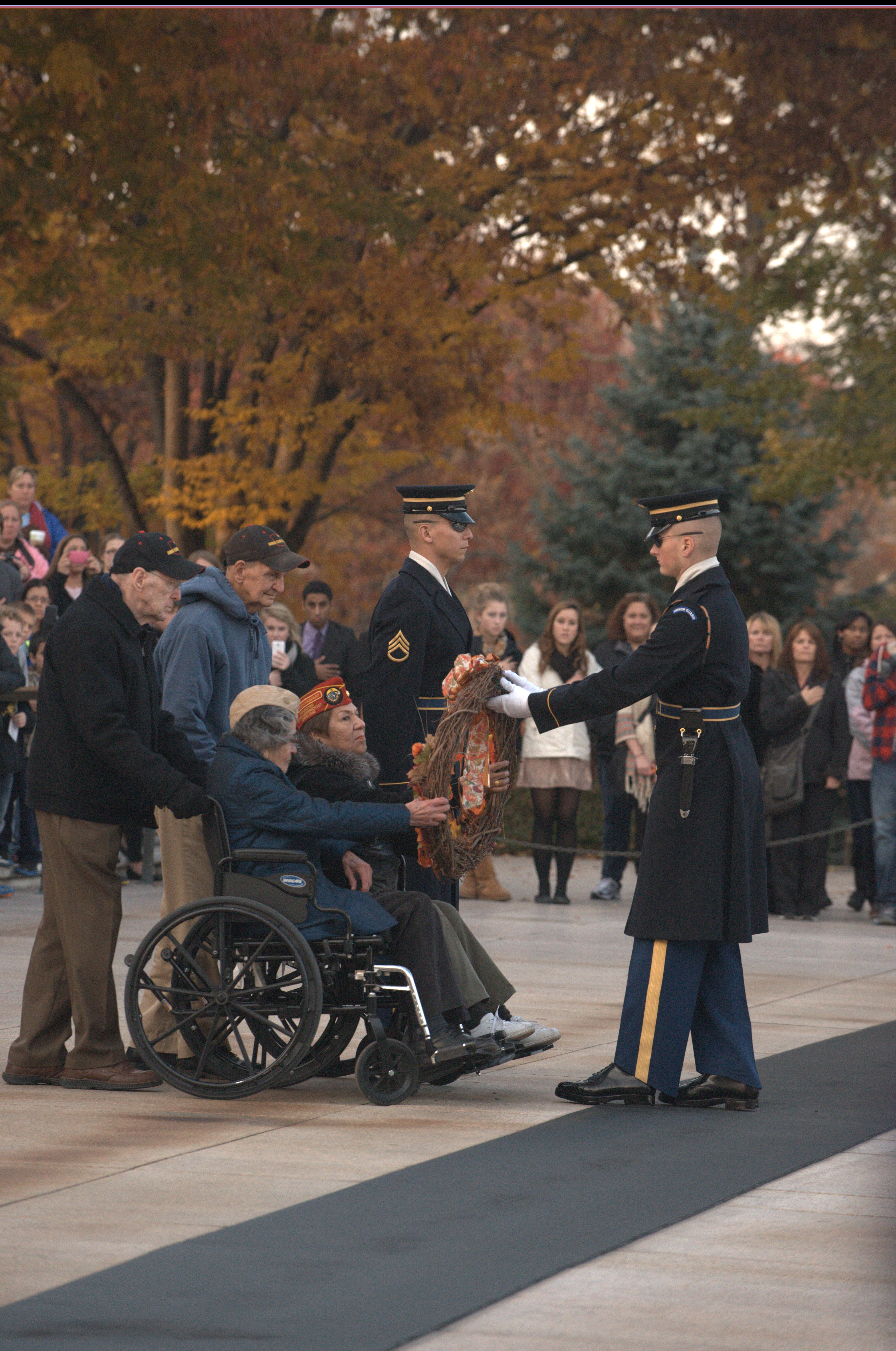 A visitor in a wheelchair lays a wreath at the Tomb of the Unknown Soldier 